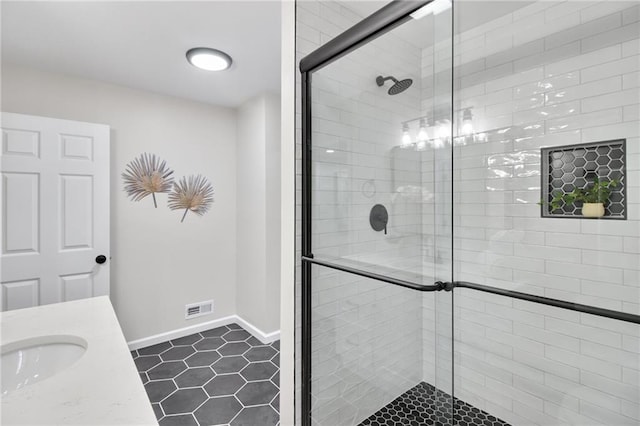 bathroom featuring walk in shower, vanity, and tile patterned flooring