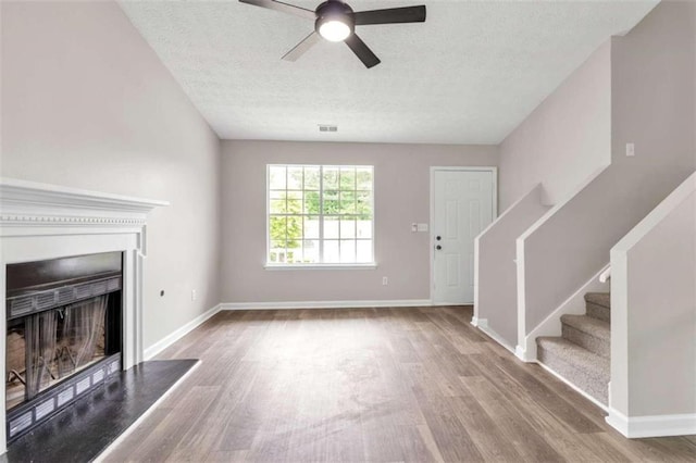 unfurnished living room featuring ceiling fan, a textured ceiling, and light wood-type flooring