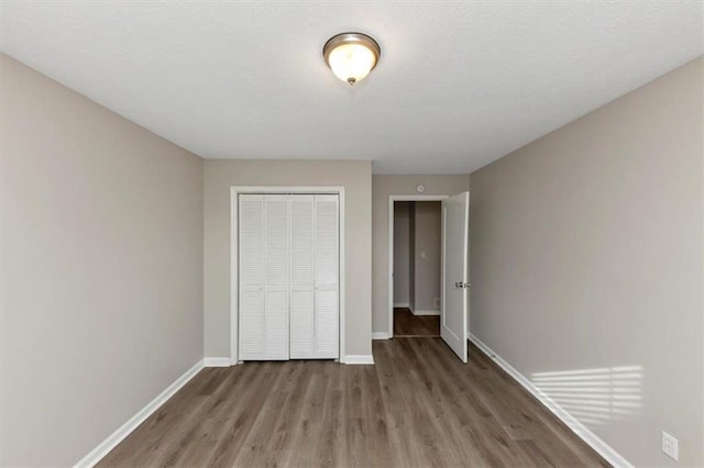 unfurnished bedroom with hardwood / wood-style floors and a closet