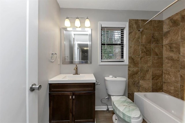 full bathroom featuring hardwood / wood-style flooring, tiled shower / bath, vanity, and toilet