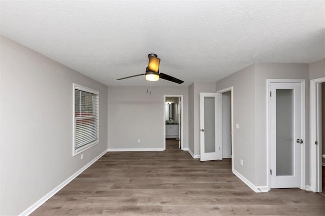 spare room featuring hardwood / wood-style flooring, ceiling fan, and a textured ceiling