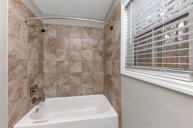 bathroom featuring tiled shower / bath