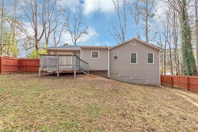 rear view of property with a deck and a lawn