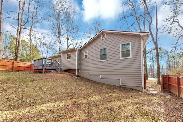 rear view of property with a deck and a lawn