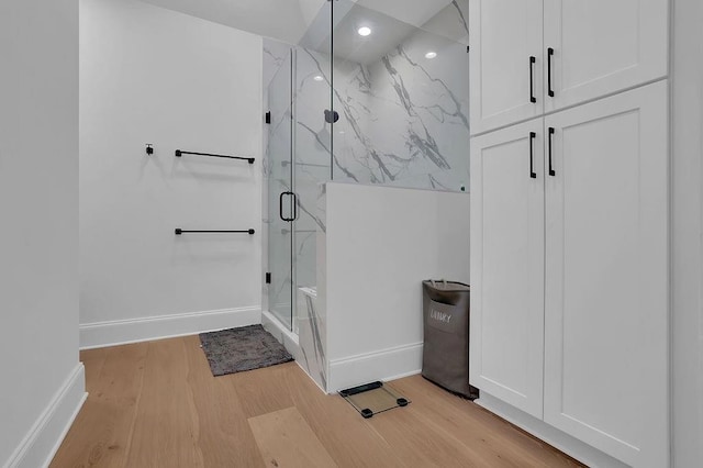 bathroom featuring an enclosed shower and wood-type flooring