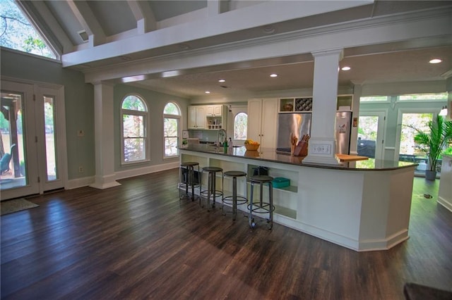 1345 Quail Hollow Dr, Hamilton, GA 31811 - bar featuring dark wood-style floors, stainless steel refrigerator, a sink, and decorative columns