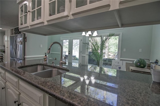 1345 Quail Hollow Dr, Hamilton, GA 31811 - kitchen featuring freestanding refrigerator, dark stone counters, a sink, and glass insert cabinets
