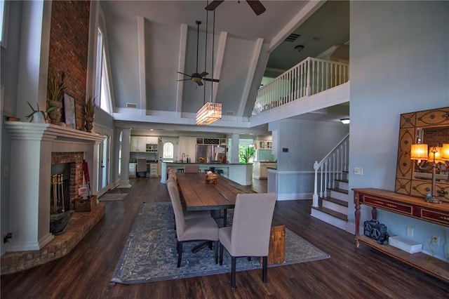 1345 Quail Hollow Dr, Hamilton, GA 31811 - dining area with a ceiling fan, dark wood-style floors, a brick fireplace, and a high ceiling