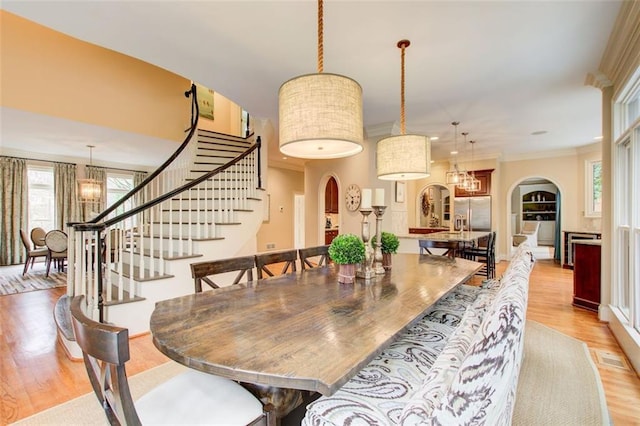 dining area featuring ornamental molding, a chandelier, and light hardwood / wood-style flooring