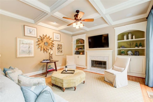 living room featuring built in shelves, beamed ceiling, coffered ceiling, and hardwood / wood-style floors