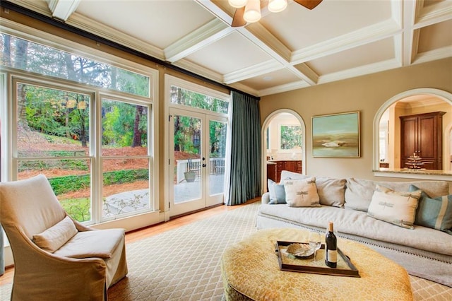 sunroom featuring coffered ceiling, beamed ceiling, a wealth of natural light, and french doors