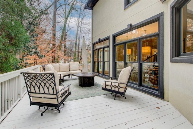 deck with an outdoor living space with a fire pit