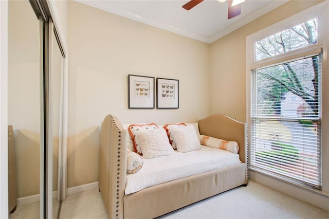 carpeted bedroom with a closet, ceiling fan, and crown molding