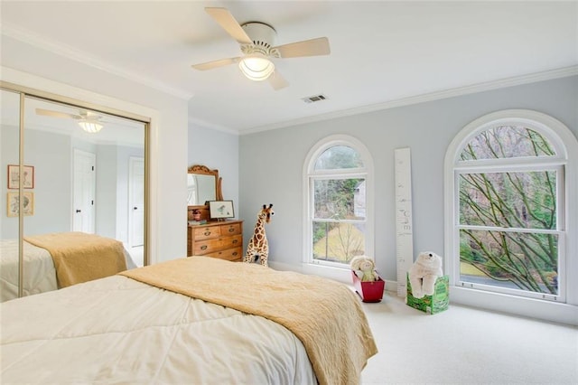 carpeted bedroom featuring crown molding and ceiling fan