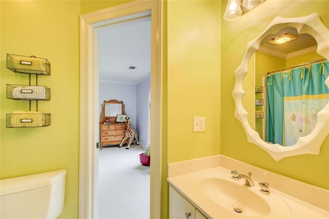 bathroom with vanity, toilet, and crown molding