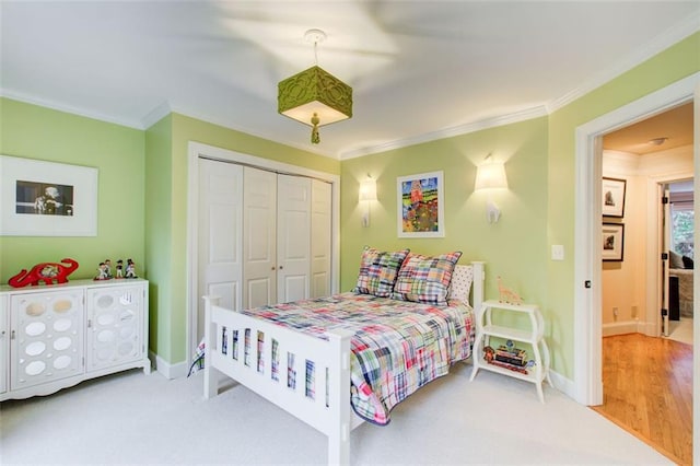 carpeted bedroom with a closet and ornamental molding