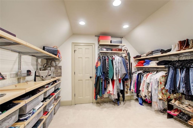 walk in closet with carpet flooring and lofted ceiling