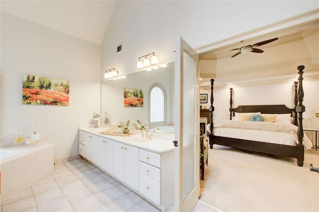 bathroom with ceiling fan, vanity, lofted ceiling, and tile patterned flooring