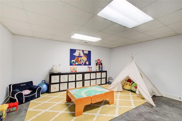 recreation room with a paneled ceiling and carpet