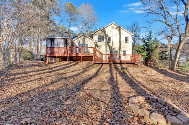 back of house with a fenced backyard, a fire pit, and a wooden deck