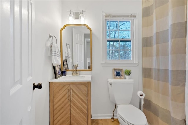 full bath featuring toilet, curtained shower, baseboards, and vanity