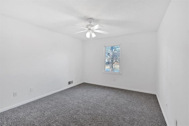 empty room featuring carpet floors, visible vents, ceiling fan, a textured ceiling, and baseboards