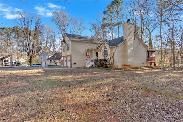 view of side of property featuring a garage and a chimney