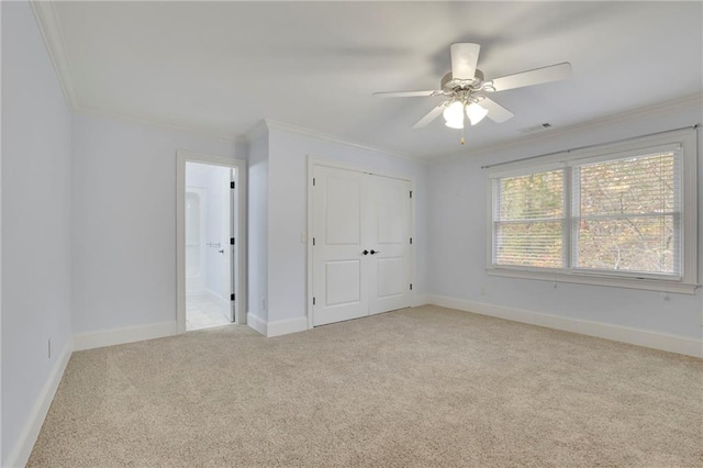 unfurnished bedroom featuring ornamental molding, light colored carpet, a closet, and ceiling fan