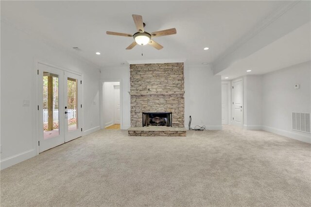 unfurnished living room featuring ornamental molding, light carpet, a fireplace, and ceiling fan