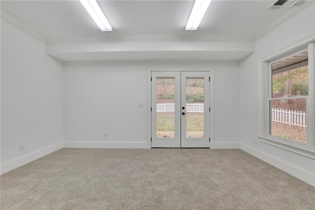 carpeted spare room with french doors, ornamental molding, and plenty of natural light