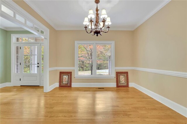 interior space featuring light hardwood / wood-style flooring, ornamental molding, and an inviting chandelier