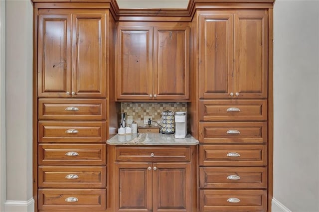 51 Mountain Ridge Dr SE, Cartersville, GA 30120 - kitchen with brown cabinets, tasteful backsplash, and light stone countertops