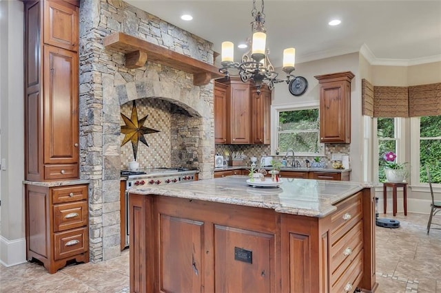 51 Mountain Ridge Dr SE, Cartersville, GA 30120 - kitchen featuring a chandelier, light stone counters, backsplash, brown cabinets, and ornamental molding