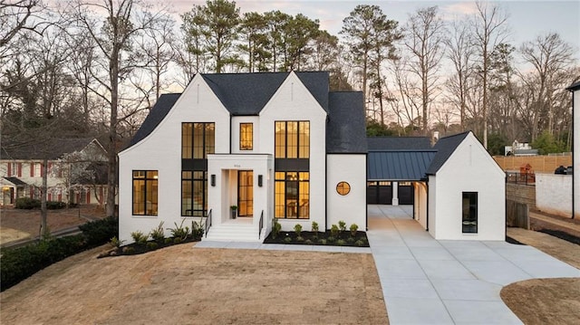 modern farmhouse with concrete driveway, a standing seam roof, and metal roof