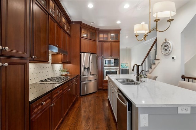 kitchen with pendant lighting, sink, backsplash, and appliances with stainless steel finishes