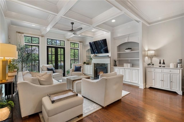 living room featuring french doors, dark hardwood / wood-style flooring, built in features, beamed ceiling, and a premium fireplace