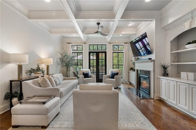 living room featuring beamed ceiling, wood-type flooring, a high end fireplace, and french doors