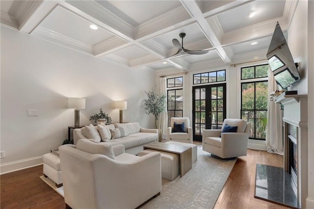 living room with french doors, coffered ceiling, hardwood / wood-style flooring, beamed ceiling, and a fireplace