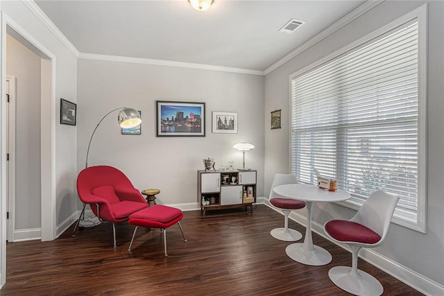 living area featuring visible vents, crown molding, baseboards, and wood finished floors