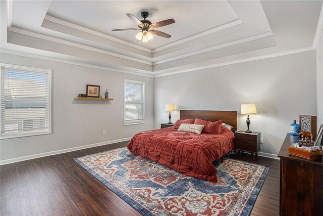 bedroom featuring a raised ceiling, baseboards, and wood finished floors