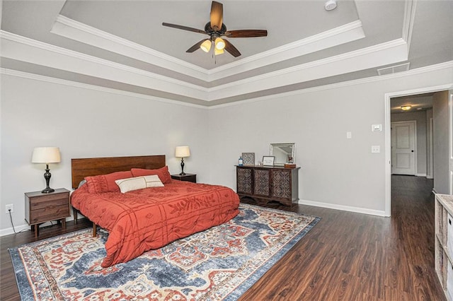 bedroom with wood finished floors, a raised ceiling, and baseboards