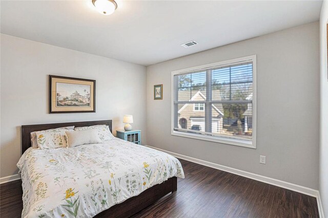 bedroom with dark wood-type flooring, visible vents, and baseboards