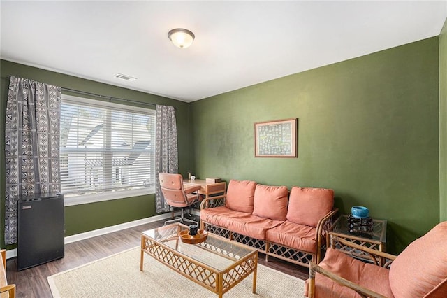 living area featuring wood finished floors, visible vents, and baseboards