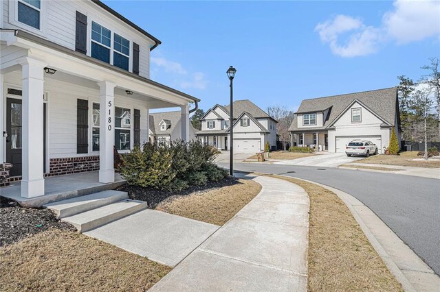 exterior space with curbs, street lighting, sidewalks, and a residential view