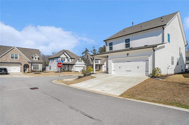 view of front of home featuring driveway, an attached garage, and a residential view