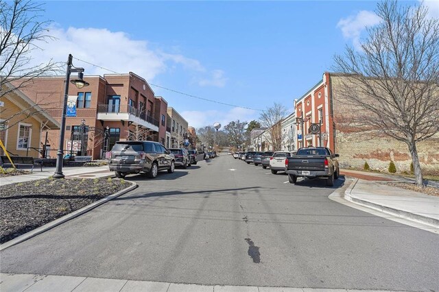 view of road with sidewalks, street lights, and curbs