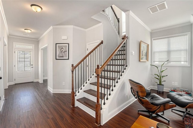 entrance foyer with baseboards, visible vents, wood finished floors, and ornamental molding