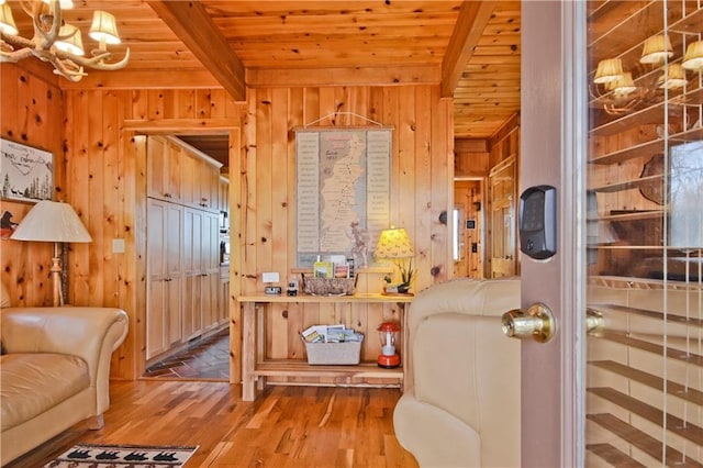 living area featuring wood walls, wood ceiling, and beamed ceiling