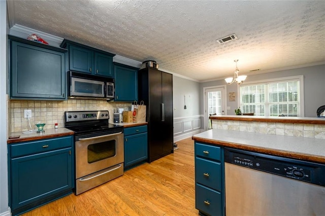 kitchen featuring visible vents, light wood-style flooring, appliances with stainless steel finishes, crown molding, and blue cabinets