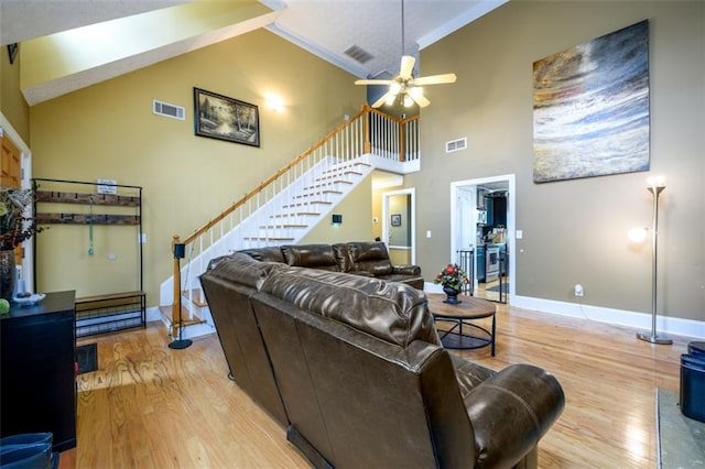 living room featuring visible vents, stairway, and light wood-type flooring